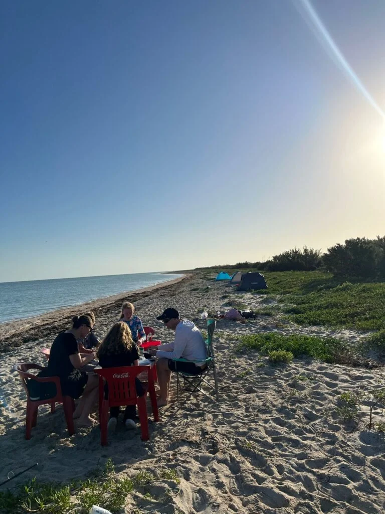 Grupo de viajeros comparte una comida frente al mar en un campamento en Ría Lagartos, Yucatán.