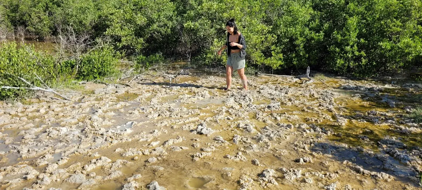 Visitante explorando el manglar rocoso al borde de la ría